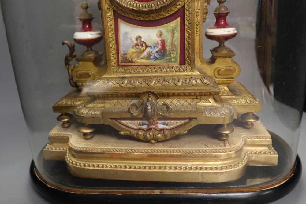 A 19th century French Louis XV style gilt spelter and porcelain mounted eight day mantel clock, on plinth, under a glass dome, with pen